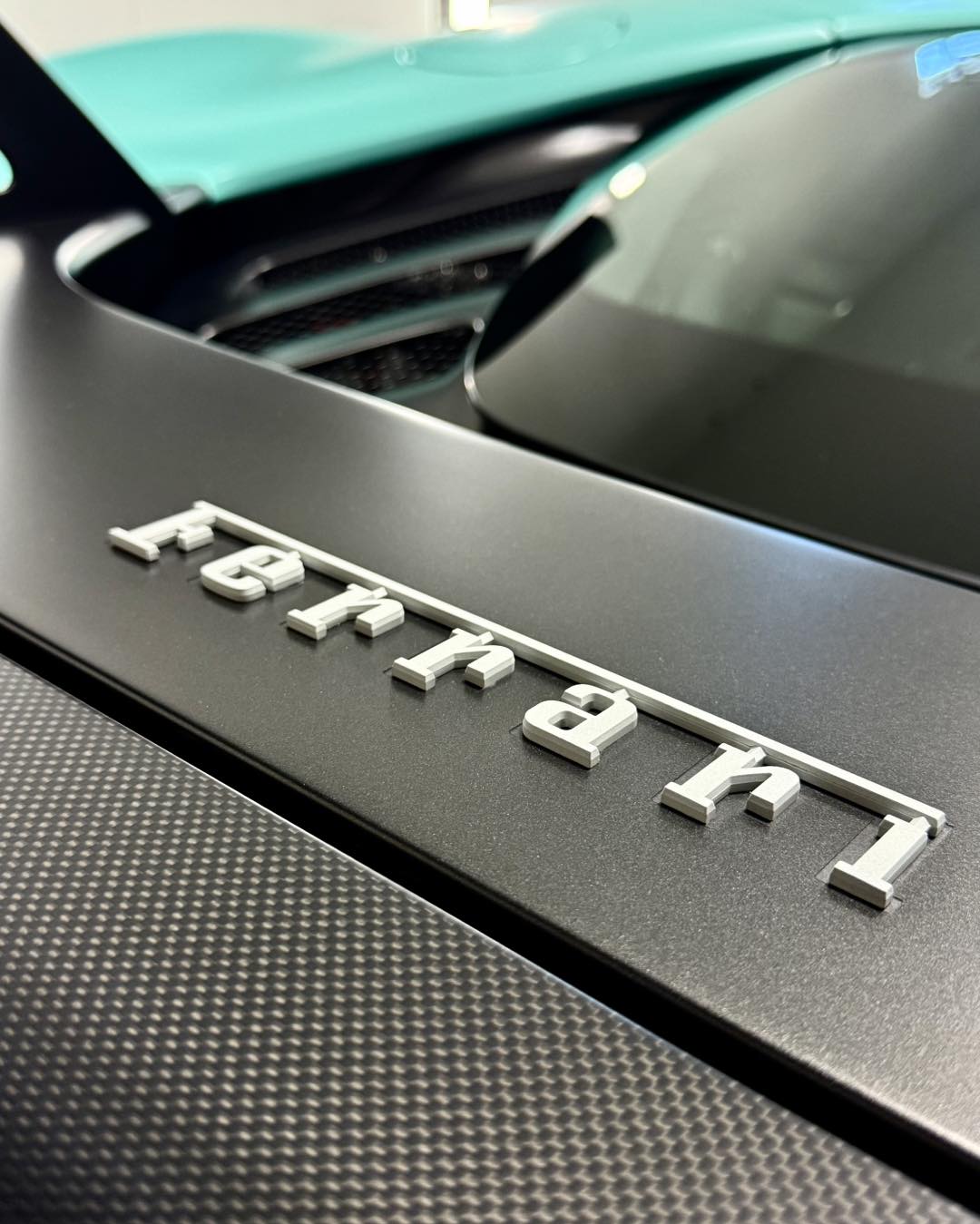 Close-up carbon-fiber detail on a Ferrari being finished by hand
